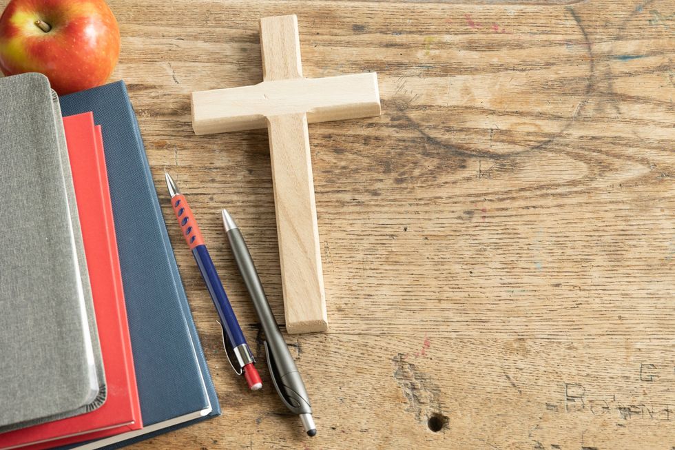 Veteran teacher suspended, faces firing for having cross by desk; law firm says school district violating free speech rights